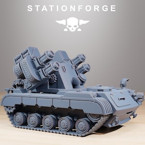 Może przedstawiać: Szary model czołgu z żywicy z napisem STATIONFORGE i logo czaszki powyżej. Pojazd posiada gąsienicowe podwozie, obrotową wieżyczkę z wieloma zamontowanymi działami oraz szczegółowe elementy mechaniczne rozmieszczone na całym kadłubie.