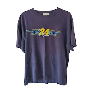 Könnte beinhalten: Ein dunkelviolettes Kurzarm-T-Shirt mit einer Grafik auf der Brust, die die gelbe Zahl 24, eine weiße Unterschrift und hellblaue, flammenartige Linienakzente zeigt. Das T-Shirt hat einen Rundhalsausschnitt und eine normale Passform.