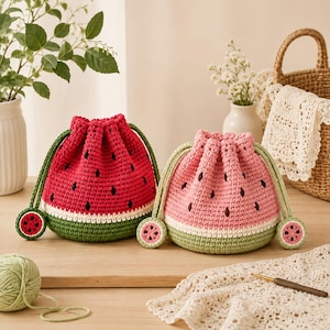 May include: Two round crochet drawstring bags shaped like watermelons. One bag is bright red with black seed accents, and the other is light pink with black seed accents. Both feature a white rind band, a green base, and green drawstring cords.