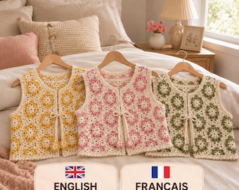 May include: Three sleeveless crochet vests hanging on wooden hangers. Each vest features a repeating floral granny square pattern in cream with yellow, pink, or green centers. Each vest has a front tie closure with small matching flower accents.