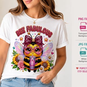 Może przedstawiać: Biały t-shirt z grafiką pszczoły z kreskówki w różowej kokardzie w panterkę, okularach w kształcie serc i z opalizującymi skrzydłami, trzymającej różowy kubek. Nad pszczołą znajduje się napis BEE FABULOUS, otoczony słonecznikami i różami.