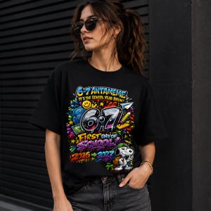 Op de afbeelding: Een zwart t-shirt met korte mouwen en een kleurrijke afbeelding met de tekst 6-7 ANTAMEME IT'S THE SCHOOL YEAR BRUH! 6-7 FIRST DAY OF SCHOOL! 2026-2027. Het ontwerp bevat schoolspullen, een papieren vliegtuigje en een cartoonhond met een groene pet.