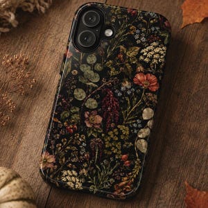 May include: A rectangular smartphone case featuring a dark black background adorned with a dense, colorful botanical pattern of various wildflowers, green foliage, and small berries, with a dual-lens camera cutout in the upper left corner.
