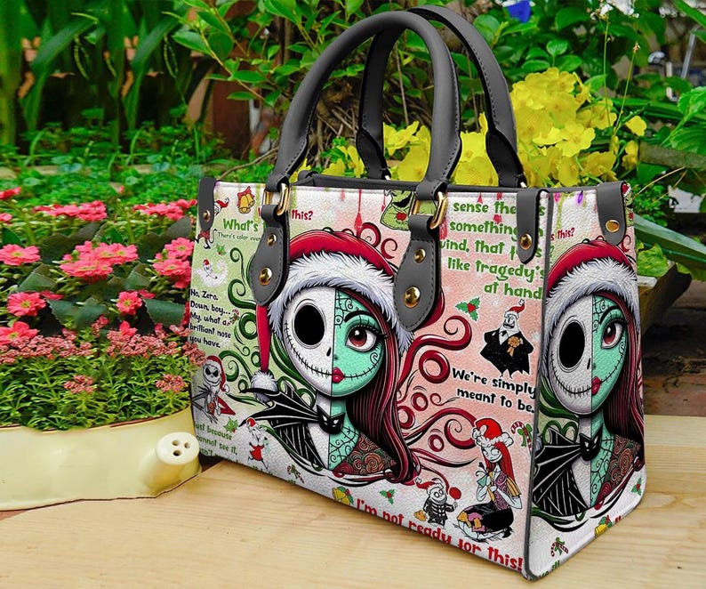 May include: A rectangular handbag with two grey handles featuring a graphic print of characters from The Nightmare Before Christmas. The design includes Sally and Jack Skellington, red Santa hats, holly, and text snippets like We're simply meant to be.