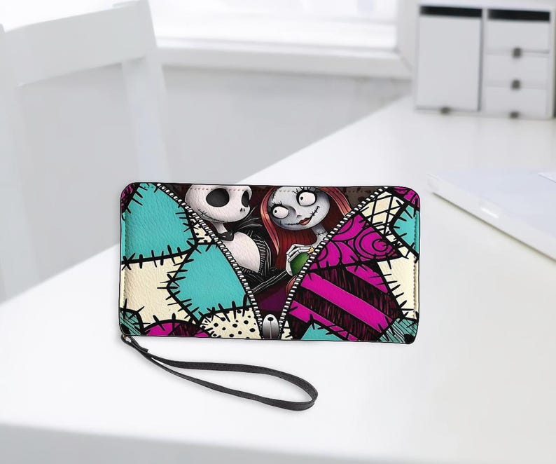 Puede incluir: Una cartera rectangular con cremallera que presenta un estampado gr&aacute;fico de Jack Skellington y Sally de Pesadilla antes de Navidad. El dise&ntilde;o incluye un patr&oacute;n de parches en tonos turquesa, rosa y crema con detalles de costuras negras.