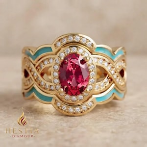 May include: A gold ring featuring a central oval-cut red gemstone surrounded by a halo of small white stones. The band displays an intricate design with turquoise enamel accents and additional white stones set along the metal curves.
