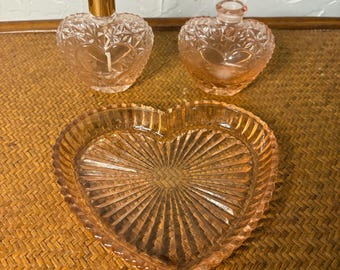 Plato para baratijas con forma de corazón de la época de la Gran Depresión con dos frascos de perfume con forma de corazón.