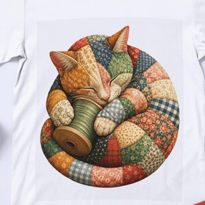 Könnte beinhalten: Ein weißes T-Shirt mit einer Grafik einer zusammengerollten Katze aus verschiedenen bunten Patchwork-Stoffmustern. Die Katze hält eine hölzerne Garnrolle mit grünem Faden zwischen ihren Pfoten. Das Design zeigt Blumen-, Karo- und Vichy-Muster.