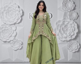 Puede incluir: Una túnica de color verde salvia con bajo asimétrico, mangas largas y bordados florales intrincados con pequeños detalles de espejo, combinada con pantalones anchos a juego. La túnica presenta una abertura central y un corpiño ajustado.