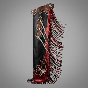 May include: A black leather chap featuring a metallic red side panel and long fringe. The upper section and decorative accents display intricate floral tooling. White leather lacing runs diagonally across the front, secured by a metal buckle at the top.