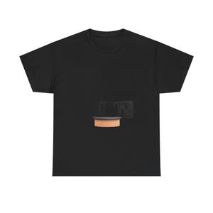 May include: A black short-sleeve t-shirt featuring a centered graphic of a dark, rectangular object with a light-colored, cylindrical base. The graphic is positioned on the chest area of the shirt, providing a contrast against the solid black fabric.