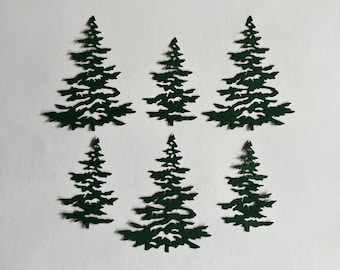 May include: Six green paper cut-out pine trees of varying sizes. The trees are all the same design, with a simple, stylized silhouette.