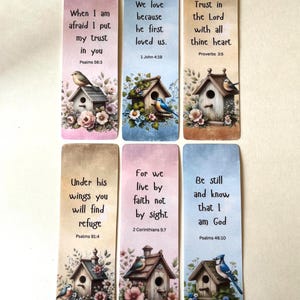May include: Set of six rectangular bookmarks with inspirational quotes and birdhouse illustrations. Each bookmark features a different Bible verse, floral accents, and a bird perched on a birdhouse. The color palette includes soft pastels and earth tones.