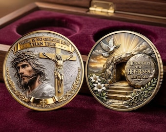 Könnte beinhalten: Zwei runde Gedenkmünzen mit religiösen Motiven. Die linke Münze zeigt Jesus mit Dornenkrone und Kreuz sowie die Inschrift "THERE IS NO GREATER LOVE THAN THIS". Die rechte Münze zeigt ein leeres Grab mit einer Taube und den Text "HE IS NOT HERE FOR HE IS RISEN, LIKE HE SAID".