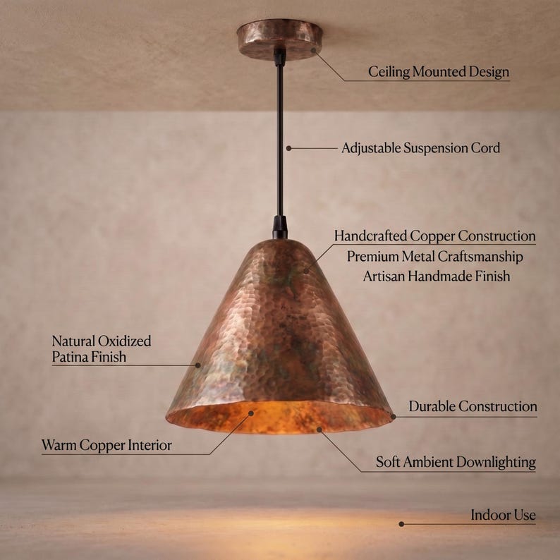 May include: A ceiling-mounted pendant light featuring a hammered copper shade with a natural oxidized patina finish. The fixture includes an adjustable black suspension cord, a warm copper interior, and provides soft ambient downlighting.