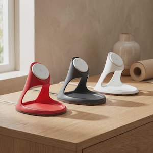 Può includere: Tre supporti di ricarica wireless in rosso, grigio scuro e bianco. Ogni supporto presenta un design curvo a telaio aperto con un pad di ricarica bianco circolare sulla parte superiore, una base piatta per il dispositivo e un cavo bianco sul retro.