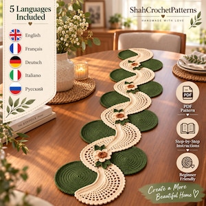 May include: A crochet table runner featuring a wavy, cream-colored lace design interspersed with solid dark green circular motifs and small, three-dimensional floral accents in cream, brown, and green. The runner is displayed on a wooden table.