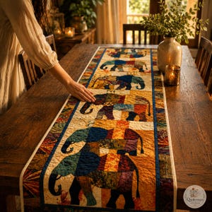 May include: A rectangular quilted table runner featuring a repeating pattern of elephants in various colors including blue, orange, red, and green. The runner has a dark blue border and a cream-colored background with intricate stitching throughout the fabric.
