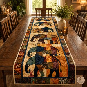 Pode incluir: Um caminho de mesa acolchoado retangular com um padr&atilde;o repetitivo de elefantes em v&aacute;rios tons de azul, castanho e laranja. O tecido &eacute; composto por quadrados de patchwork com costuras intrincadas, orlado por um acabamento azul escuro.