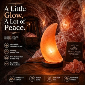 Può includere: Una lampada di sale rosa dell'Himalaya a forma di mezzaluna con una calda luce arancione, montata su una base circolare in legno scuro. La lampada è accompagnata da un piccolo cartello in legno con l'etichetta 100% PURE HIMALAYAN PINK SALT.