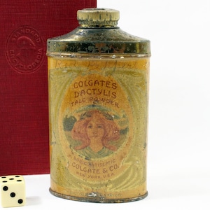May include: Vintage Colgate's Dactylis Talc Powder tin with a gold lid and a yellow label featuring a woman with red hair and the text "Colgate's Dactylis Talc Powder" and "Boracic Antiseptic Colgate & Co. New York, U.S.A."