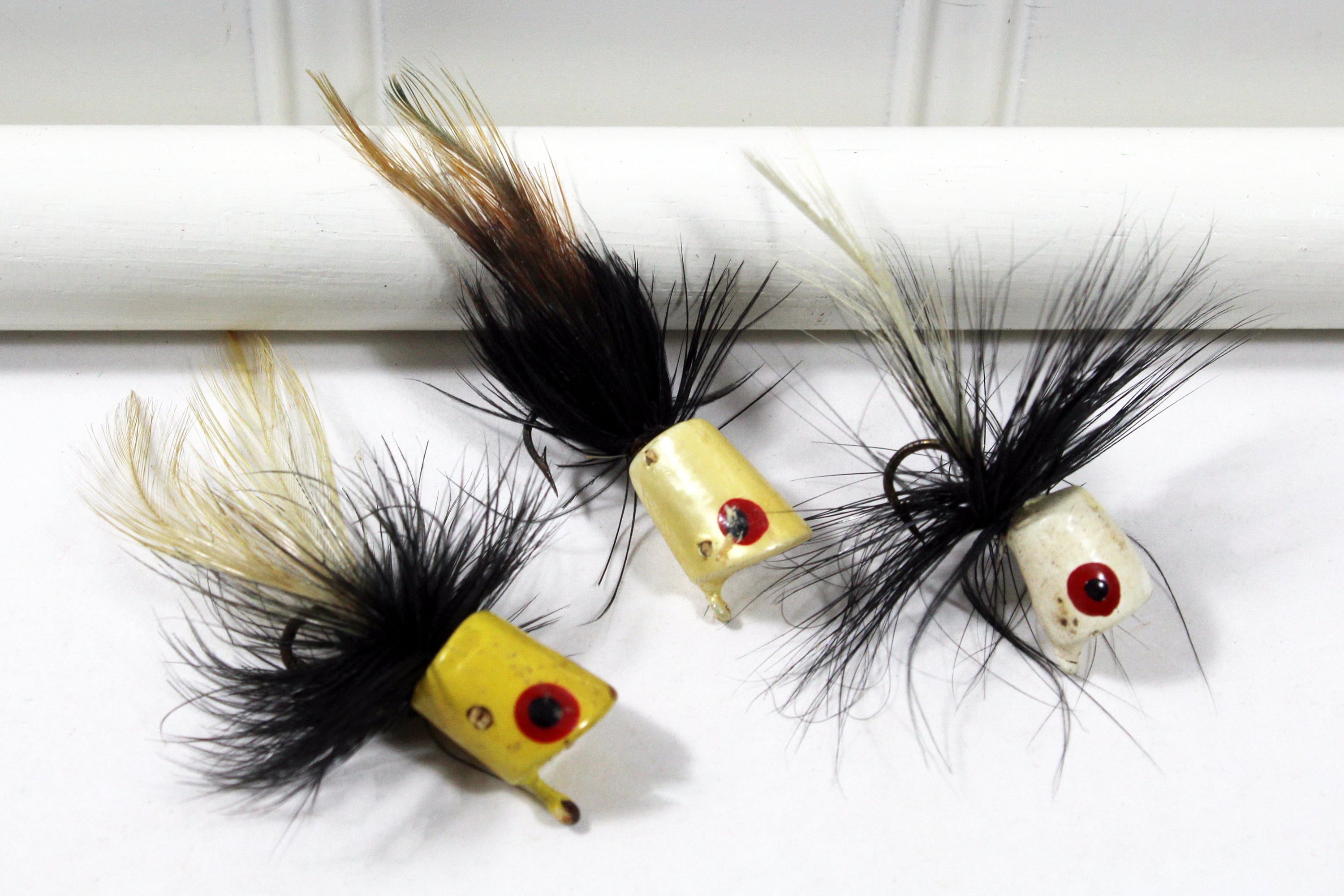 Three Vintage Feather Poppers Fishing Lures Yellow, Black, and