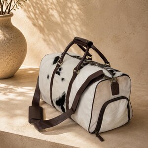 Luxury cowhide duffle bag, hair on hide travel bag, full grain leather weekender, overnight bag men, overnight bag women, luxury travel bag, cowhide weekender bag, carry on duffle, western travel bag, premium leather duffle, handcrafted travel bag, genuine cowhide luggage, luxury weekend bag