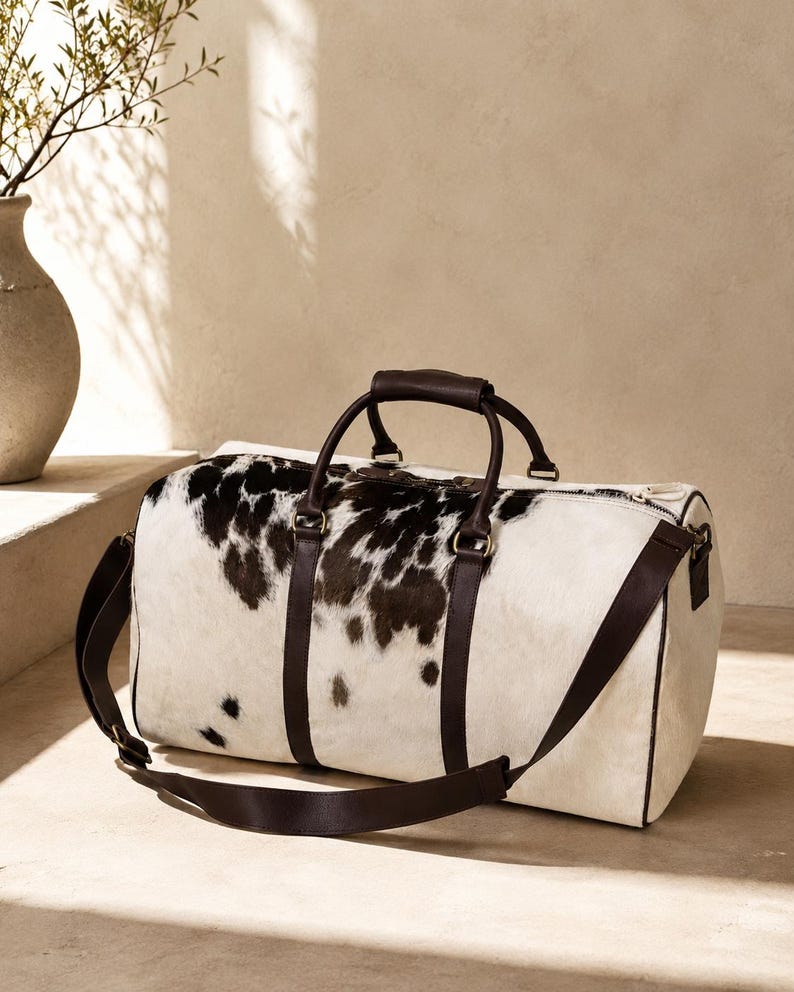 Luxury cowhide duffle bag, hair on hide travel bag, full grain leather weekender, overnight bag men, overnight bag women, luxury travel bag, cowhide weekender bag, carry on duffle, western travel bag, premium leather duffle, handcrafted travel bag, genuine cowhide luggage, luxury weekend bag