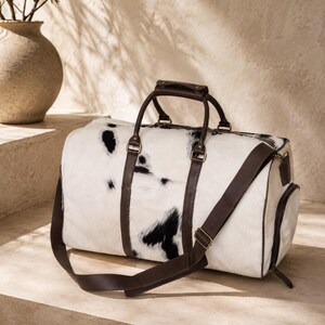 Luxury cowhide duffle bag, hair on hide travel bag, full grain leather weekender, overnight bag men, overnight bag women, luxury travel bag, cowhide weekender bag, carry on duffle, western travel bag, premium leather duffle, handcrafted travel bag, genuine cowhide luggage, luxury weekend bag