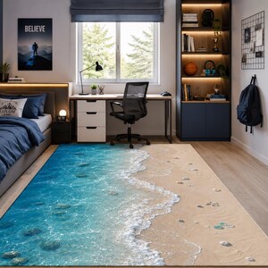 Peut inclure: Un tapis rectangulaire présentant une impression haute résolution d'une scène de plage. Le motif affiche une eau de mer bleu clair avec des vagues d'écume blanche s'échouant sur un rivage sablonneux parsemé de petits galets et coquillages.