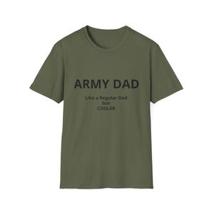 May include: An olive green short-sleeved t-shirt featuring black text printed on the chest that reads: ARMY DAD, Like a Regular Dad, but COOLER. The shirt has a classic crew neckline and a straight hemline, presented in a simple, flat layout.
