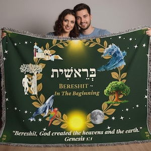 May include: A dark green woven throw blanket featuring a central gold laurel wreath, Hebrew text, and the English words Bereshit, In The Beginning. Illustrations include a tree, a whale, a parrot, a moon, and the text Genesis 1:1.