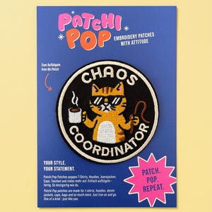 Könnte beinhalten: Ein kreisförmiger, aufbügelbarer Stickaufnäher mit einer orangefarbenen getigerten Katze, die eine Sonnenbrille trägt und eine Kaffeetasse sowie eine Peitsche hält. Der Text CHAOS COORDINATOR steht in weißen Buchstaben auf schwarzem Grund.