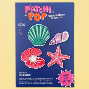 May include: A blue display card featuring four embroidered iron-on patches: a teal scallop shell, a purple spiral shell, a pink clam shell with a white pearl, and a pink starfish. The card includes the text Patchi Pop, Embroidery Patches With Attitude, and Patch. Pop. Repeat.