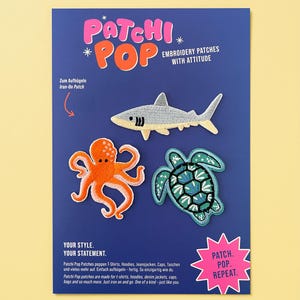 Könnte beinhalten: Eine blaue Präsentationskarte mit drei gestickten Aufbügel-Patches: ein grauer Hai, ein orangefarbener Oktopus und eine türkisfarbene Meeresschildkröte. Die Karte enthält den Text Patchi Pop, Embroidery Patches With Attitude, Your Style. Your Statement. und Patch. Pop. Repeat.