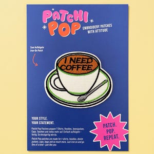 Peut inclure: Un écusson thermocollant brodé représentant une tasse de café blanche sur une soucoupe avec une cuillère, contenant un liquide orange avec le texte noir I NEED COFFEE. L'écusson est sur un carton bleu avec le texte PATCHI POP et PATCH. POP. REPEAT.