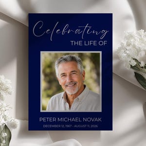 May include: A rectangular funeral program card with a deep navy blue background. The text reads Celebrating THE LIFE OF, followed by a centered photograph of a smiling man, and the name PETER MICHAEL NOVAK with dates December 12, 1967 - August 11, 2026.