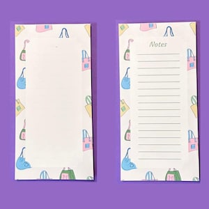 May include: Two rectangular paper notepads featuring a repeating pattern of colorful illustrated handbags on the borders. The left notepad has a blank white center, while the right notepad includes the word Notes and horizontal lines for writing.