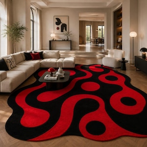 May include: An area rug featuring an irregular, organic shape with a bold pattern of interconnected red and black fluid, wavy lines and circular motifs. The rug covers a large portion of the floor, displaying a high-contrast design throughout.
