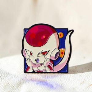 Peut inclure: Un pin's en émail carré représentant un personnage de dessin animé avec une tête rose pâle et blanche, des yeux rouges et une longue queue. Le personnage est sur un fond bleu foncé avec deux sphères orange marquées d'une étoile rouge.