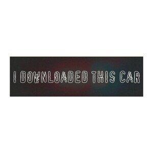 May include: A rectangular black sticker featuring the white outlined text I DOWNLOADED THIS CAR in a stylized, slightly distorted font. The background is a solid dark matte black with subtle hints of red and blue light gradients.