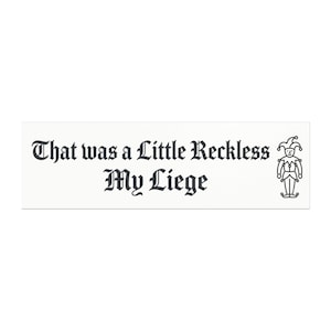 May include: A rectangular white sticker featuring the black text "That was a Little Reckless My Liege" in a gothic-style font. To the right of the text is a simple black line drawing of a jester wearing a traditional cap with bells.