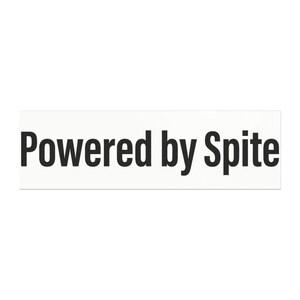 May include: A rectangular white sticker featuring the text "Powered by Spite" printed in a bold, black, sans-serif font. The design is centered on the white background, presenting a clear and high-contrast visual statement in a simple format.