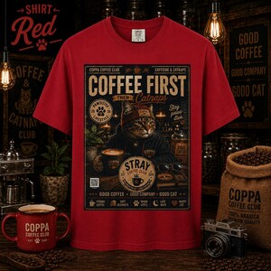 May include: A red short-sleeved t-shirt featuring a graphic print of a cat wearing a beanie and hoodie. The text reads COFFEE FIRST THEN CATNAPS, COPPA COFFEE CLUB, CAFFEINE & CATNAPS, PAWSITIVE LIFESTYLE, STRAY COFFEE CLUB, and GOOD COFFEE GOOD COMPANY GOOD CAT.