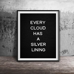May include: A black letter board with a white frame, displaying the quote "Every cloud has a silver lining."