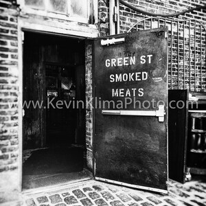 Może przedstawiać: Czarno-białe zdjęcie witryny sklepowej z drzwiami, na kt&oacute;rych widnieje napis "Green St Smoked Meats" oraz adres strony internetowej.
