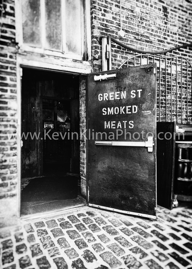Może przedstawiać: Czarno-białe zdjęcie witryny sklepowej z drzwiami, na kt&oacute;rych widnieje napis "Green St Smoked Meats" oraz adres strony internetowej.