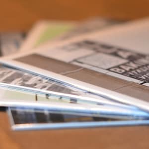 Op de afbeelding: Een stapel van vier witte paperbacks met zwarte tekst op de omslagen. Het bovenste boek heeft de tekst "BAKING" en "VIENNA" op de omslag.