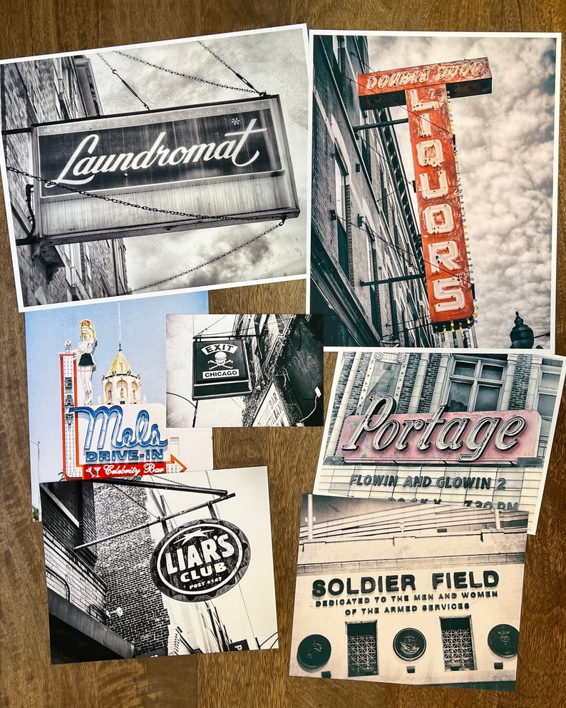 Op de afbeelding: Een verzameling vintage borden uit Chicago, waaronder een wasserette, een slijterij, een drive-in, een club en Soldier Field. De borden zijn allemaal in zwart-wit, met enkele rode en blauwe accenten.