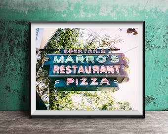 May include: A framed wall art print featuring a dark green, multi-tiered neon sign for Marro's Restaurant. The sign displays the text COCKTAILS, MARRO'S, RESTAURANT, and PIZZA in illuminated lettering against a background of green trees and bright sky.